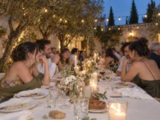 The long dinner table under string lights.